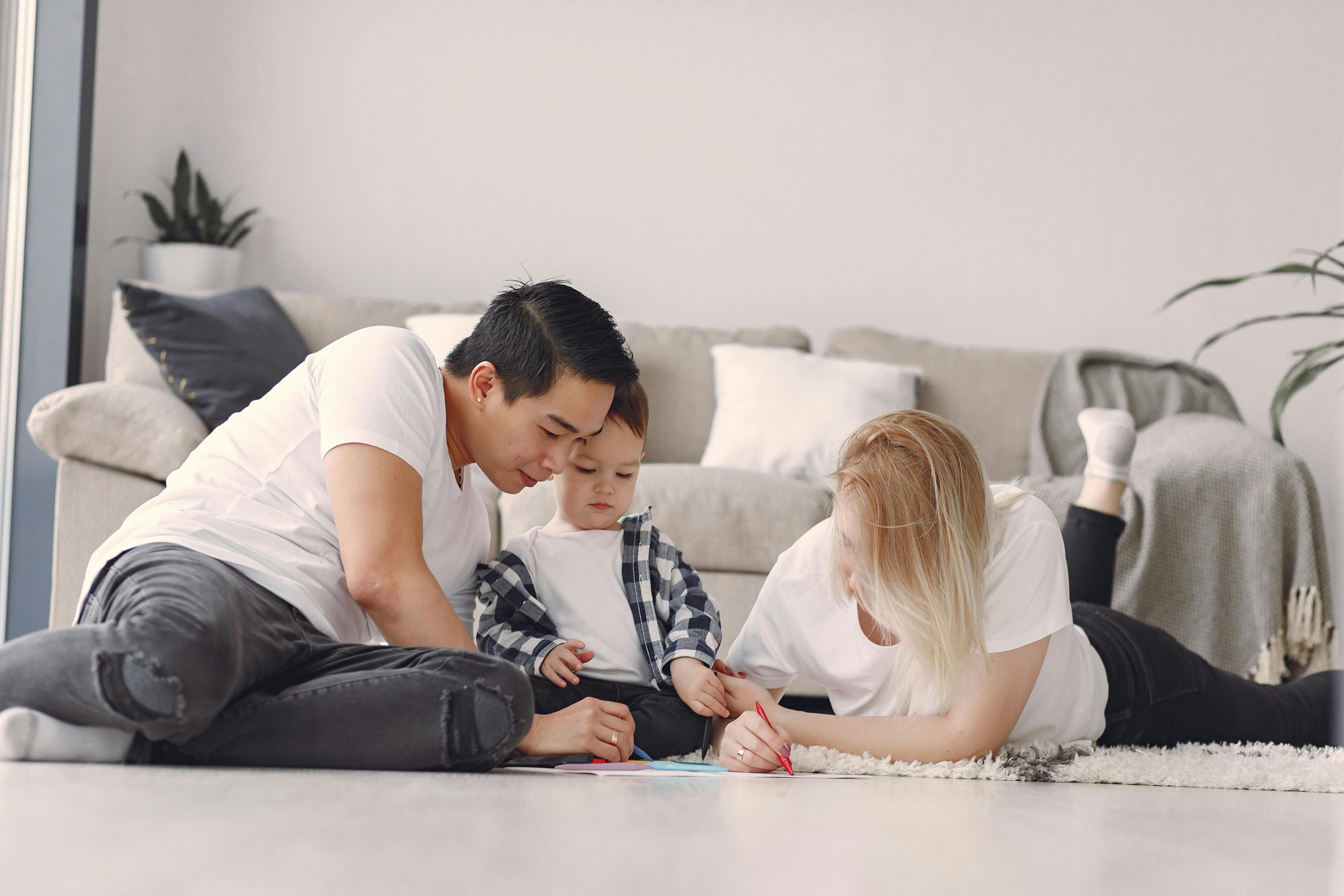 Ouders met kind en stiften op grond